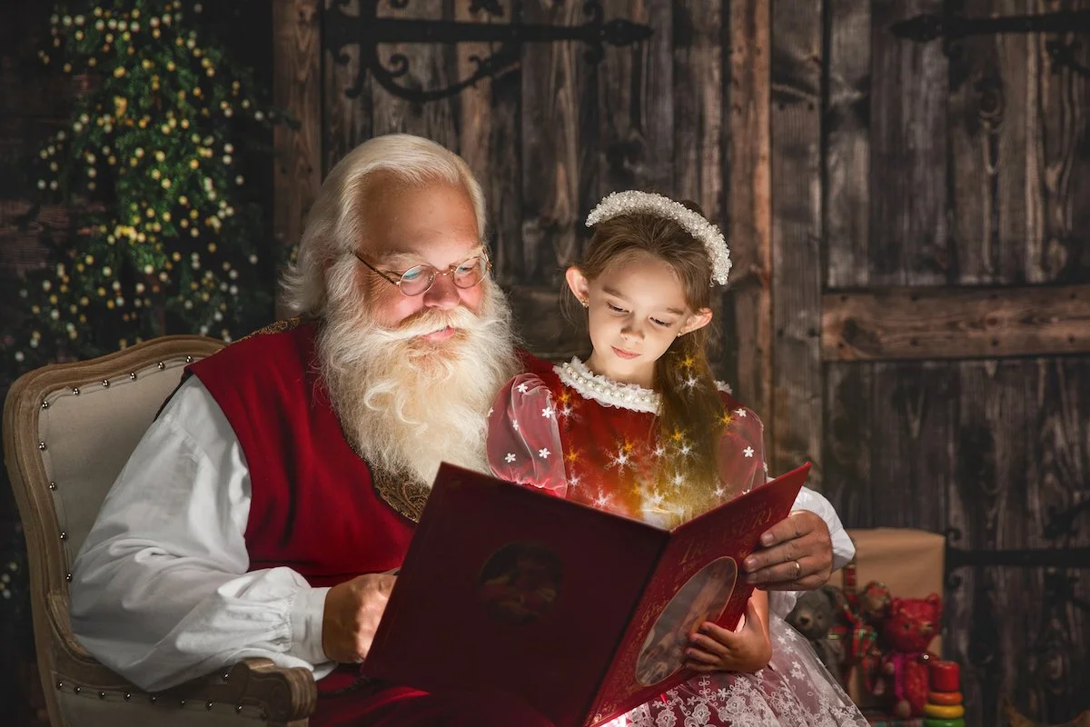 Santa reading a story to an elf.